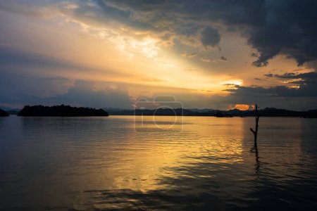 rays of sunset through cloud with reflection on water at Pom Pee reservoir viewpoint in Vajiralongkorn dam in Khao Laem National Park, Kanchanaburi, Thailand.