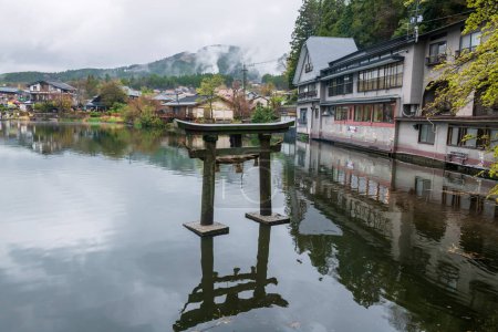 Ancient Torii gate at Kinrin Lake in sightseeing spot of Mount Yufu at spring. Famous travel destination landmark of Yufuin in Oita District, Kyushu, Japan.