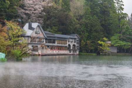 Kinrin lake with heavy rain, mist, and hotel sightseeing spot in spring at the foot of Mount Yufu, Yufuin, Oita, Kyushu, Japan. Famous travel destination.