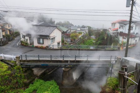 Houses along canal with heavy steam and mist in Beppu city, Oita, Japan. Famous travel destination for hot spring resorts for onsen bath.