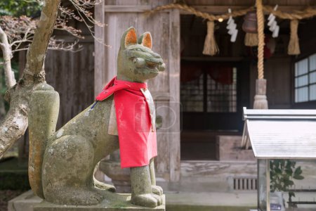 Estatua de zorro Kitsune en Homangu Kamado shrine, Dazaifu, Kyushu., Japón. Santos zorros embaucadores del folklore tradicional japonés. Santuario inspiran para Kimetsu no Yaiba: Cazadora de demonios.