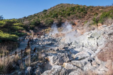 People walk to visit Hell valley Jigoku at Mount Unzen onsen hot springs resort by Shimabara city, Nagasaki, Kyushu, Japan. Hot water, sulfur gases and steam spout out by heated volcanic spring field.