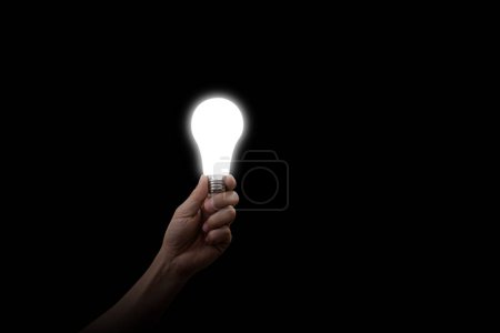 Téléchargez les photos : Main mâle tenant ampoule LED avec éclairage sur fond sombre - en image libre de droit