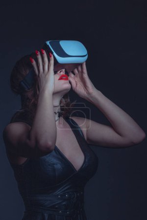 Téléchargez les photos : Femme sexy avec lèvres rouges et casque profitant de la réalité virtuelle au portrait de nuit - en image libre de droit