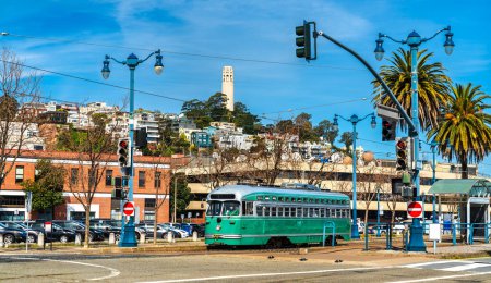 Historic streetcar on the Embarcadero with the iconic Coit Tower in the background. San Francisco, California
