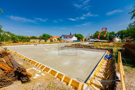Photo for Zrenjanin, Vojvodina, Serbia - June 29, 2022: Freshly poured leveled concrete in the mold made of yellow wooden planks, building foundation, construction site. - Royalty Free Image