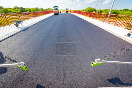 Photo for Ultrasonic grade, slope, non-contact sensor, (multiplex) sensing positioning, and correcting the measured value, height of fresh asphalt, accordingly, placed on road laying construction machine. - Royalty Free Image