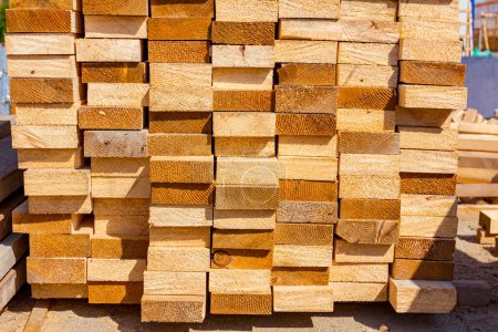 Photo for Yellow wooden chopped planks arranged in a row placed at the alfresco on the construction site. - Royalty Free Image
