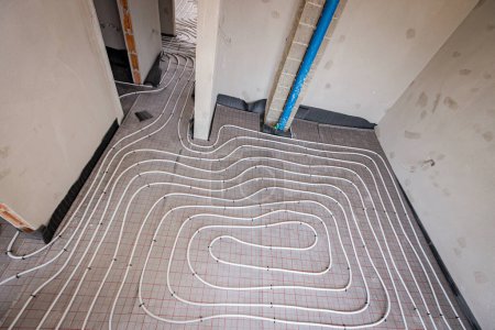 Téléchargez les photos : Système de tuyauterie de chauffage au sol monté dans un bâtiment résidentiel en construction - en image libre de droit