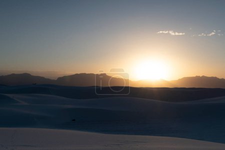 Direct sunset over the mountains in white sand dunes national park