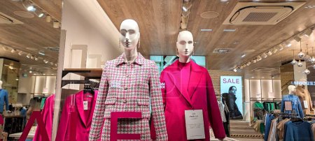 Foto de Austria, Viena - 9 de enero de 2023: Tienda de ropa exterior femenina de la marca alemana Hallhuber. Maniquíes femeninos vestidos con abrigos - Imagen libre de derechos