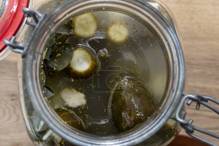 Téléchargez les photos : Concombres marinés au raifort et à l'ail dans un grand bocal en verre, un plat polonais traditionnel. - en image libre de droit