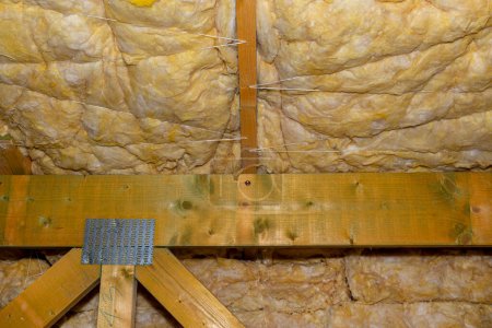 Isolation des murs et du plafond dans le grenier en laine minérale entre les fermes, liée par une ficelle de polypropylène.