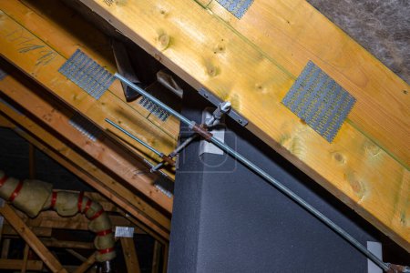 Photo for Steel fixing of the ceramic chimney to the trusses inside the attic. - Royalty Free Image