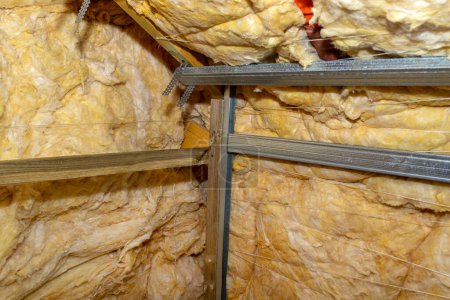 Téléchargez les photos : Aluminum frame with hangers placed on beams in the attic for mounting plasterboards - en image libre de droit