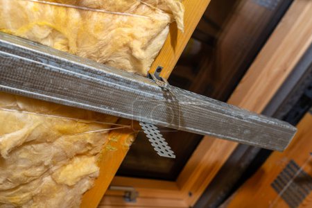 Foto de Aluminum frame with hangers placed on beams in the attic for mounting plasterboards - Imagen libre de derechos