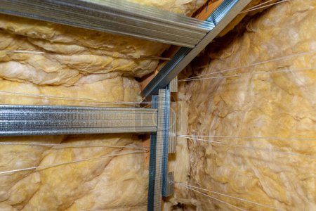 Téléchargez les photos : Aluminum frame with hangers placed on beams in the attic for mounting plasterboards. - en image libre de droit