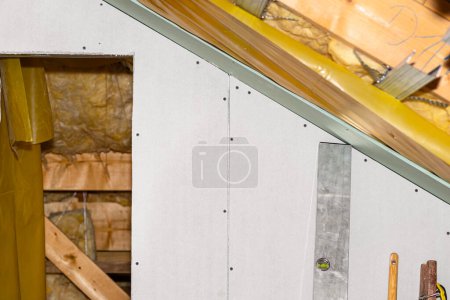 Téléchargez les photos : Mounted white plasterboards to an aluminum loft frame, visible yellow vapor barrier foil. - en image libre de droit