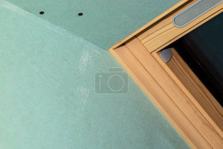 Téléchargez les photos : Mounted green plasterboards to an aluminum loft frame, roof window visible. - en image libre de droit