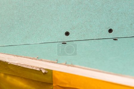 Téléchargez les photos : Mounted green plasterboards to an aluminum loft frame, visible yellow vapor barrier foil. - en image libre de droit