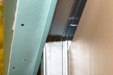 Téléchargez les photos : Mounted green plasterboards to an aluminum loft frame, visible black screws. - en image libre de droit