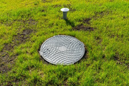 Photo for Hatch and vent from a household septic tank with no outflow placed in the garden. - Royalty Free Image