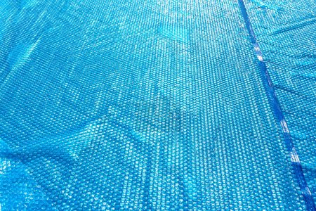 Téléchargez les photos : A large expansion pool with a diameter of 3.96 m, set in the yard next to the house, covered with a solar mat. - en image libre de droit