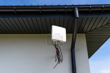 Téléchargez les photos : Amplificateur d'antenne pour internet mobile à la maison, monté sur la façade de la maison à l'extérieur. - en image libre de droit