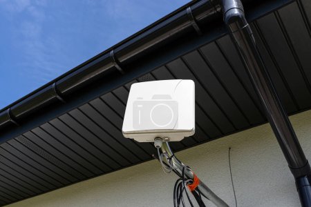 Téléchargez les photos : Amplificateur d'antenne pour internet mobile à la maison, monté sur la façade de la maison à l'extérieur. - en image libre de droit