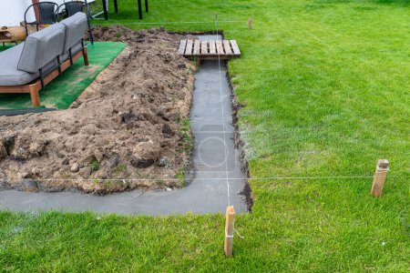 Foto de Los cimientos se vertían en una zanja en el patio, construyendo una terraza en el patio trasero. - Imagen libre de derechos