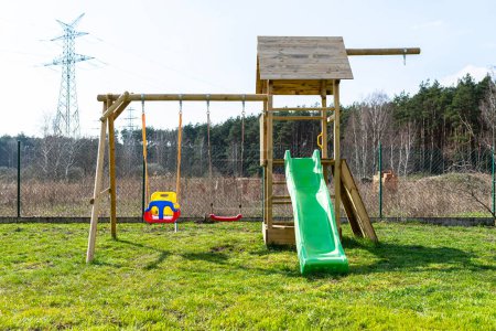Ein Kinderspielplatz im Garten besteht aus unbemalten Hölzern.