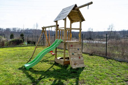 Ein Kinderspielplatz im Garten besteht aus unbemalten Hölzern.