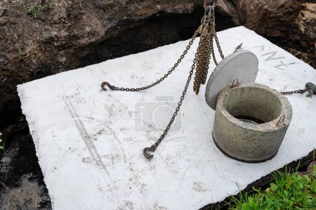 Photo for Concrete septic tank with a capacity of 10 m3 located in the garden next to the house, visible cover with manhole. - Royalty Free Image