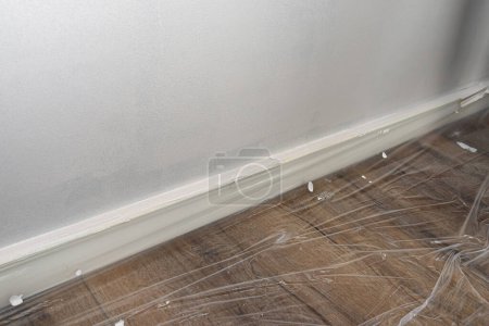 The vinyl floor is protected with foil before painting and covered with painters tape.