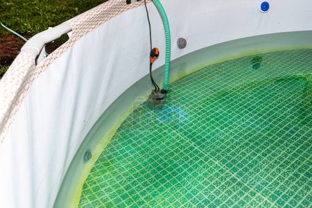 Vaciar el agua usada de una piscina de jardín usando una bomba de agua casera.