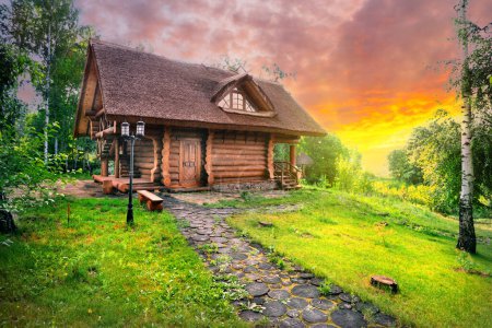 Photo for Path and wooden house in a birch grove under dramatic sunset skies - Royalty Free Image