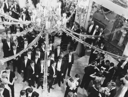 Foto de Vista de ángulo alto de las personas disfrutando mientras bailan en la fiesta bajo la lámpara de araña decorada en la discoteca - Imagen libre de derechos