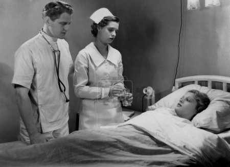 Foto de Enfermera y médico hablando y consolando a un paciente en una cama de hospital - Imagen libre de derechos