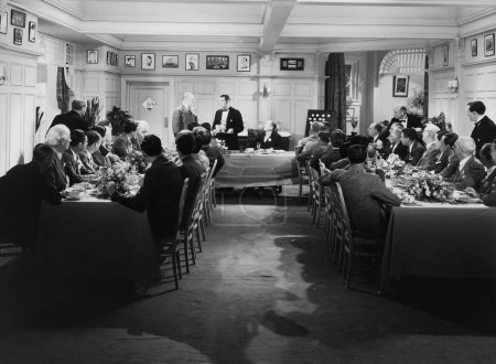 Foto de Camarero sirviendo a hombre de negocios mientras la gente de negocios se sienta a la mesa durante la fiesta del té - Imagen libre de derechos