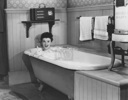 Foto de Feliz joven mujer disfrutando de baño en la bañera en casa - Imagen libre de derechos