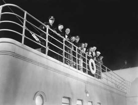 Foto de Vista de bajo ángulo del capitán y los pasajeros en el barco contra el cielo por la noche - Imagen libre de derechos