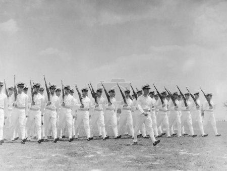 Foto de Comandante naval lidera un grupo de soldados que marchan portando rifles - Imagen libre de derechos