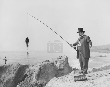 Foto de Hombre la captura de peces con caña en la playa en el día soleado - Imagen libre de derechos
