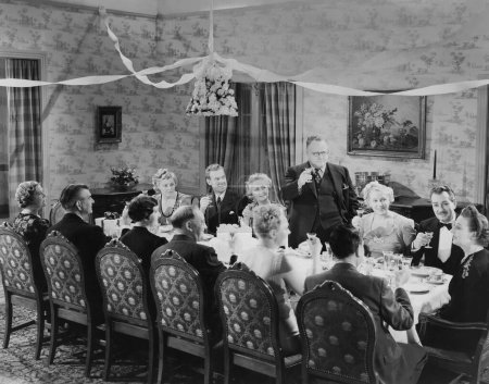 Foto de Felices familiares y amigos celebrando juntos mientras brindan en la mesa del comedor - Imagen libre de derechos