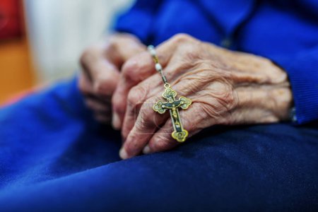 Photo for Close-up of old woman's hands with rosary and small cross - Royalty Free Image