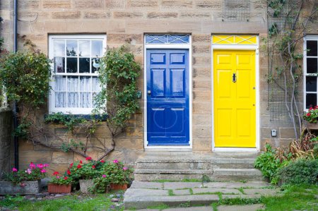 Téléchargez les photos : Portes avant peintes en bleu et jaune sur des maisons mitoyennes. Maisons de vacances, Robin Hoods Bay, Yorkshire, Royaume-Uni - en image libre de droit