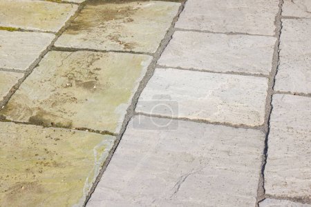 Cleaning sandstone paving. Garden patio before and after jet washing or pressure washing, UK. 