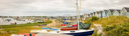 Téléchargez les photos : DORSET, UK - July 07, 2022. Rows of boats and beach huts at the seaside. Panoramic view of Hengistbury Head and Christchurch Harbour - en image libre de droit