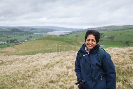 Photo for British Asian Indian woman in waterproof coat hiking in Snowdonia National Park near Lake Bala, North Wales, UK - Royalty Free Image