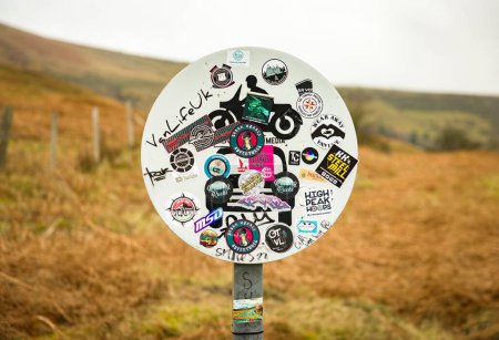 Foto de PEAK DISTRICT, Reino Unido - 28 de febrero de 2023. Blogger influencer stickers on a no motorvehicles sign in Derbyshire, UK. Concepto Van Life. - Imagen libre de derechos